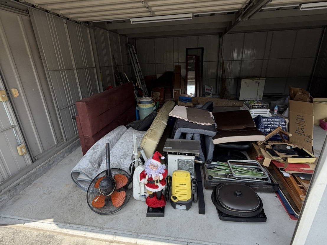 片付け前の倉庫:家具・家電・段ボールが積まれた状態